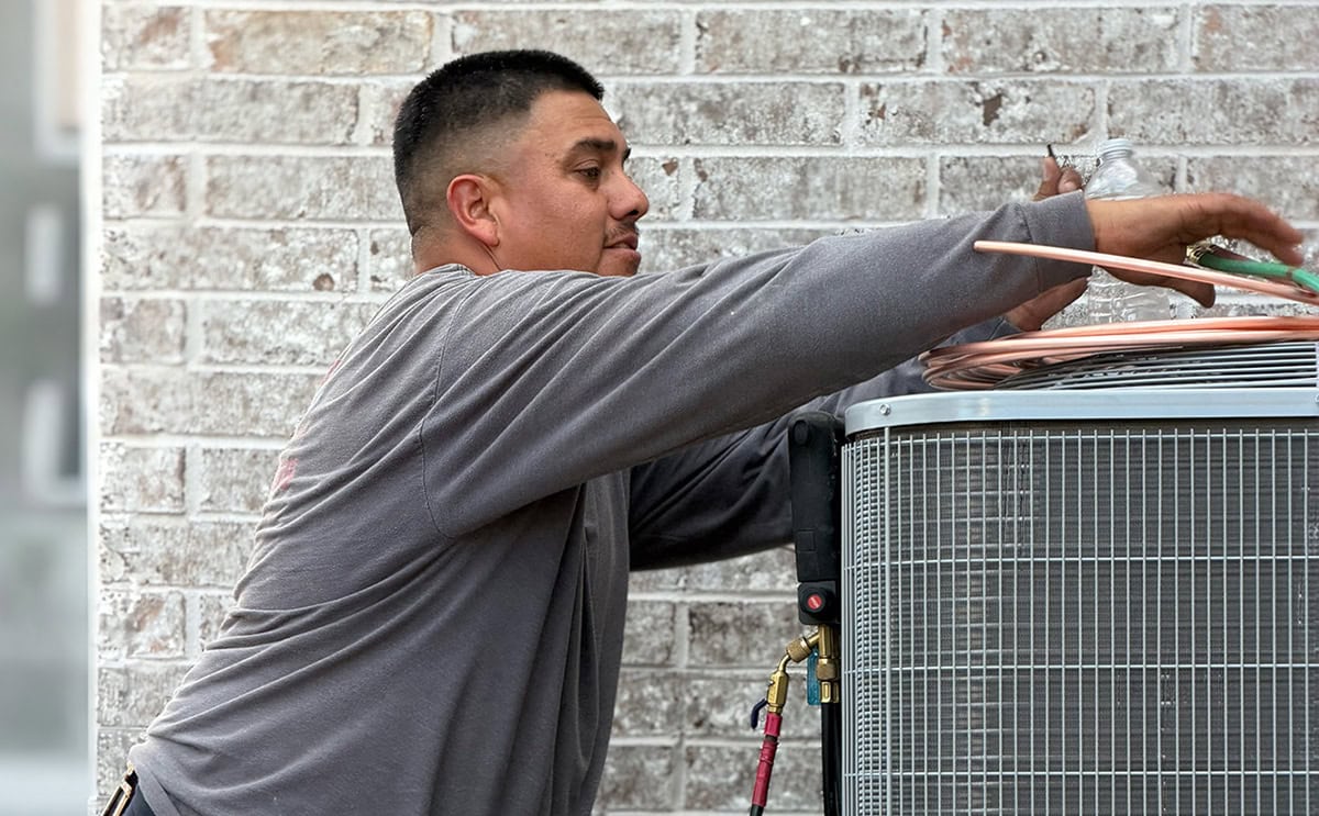 Air Conditioning Technician fixing a AC Unit in Lowell, AR